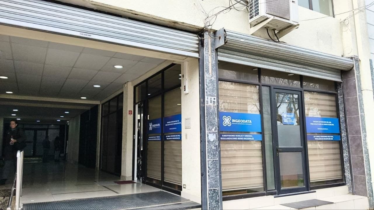 Acceso a la oficina de INGEODATA en Arauco 409, Chillán, con letreros de subdivisiones rurales y regularizaciones en las vitrinas